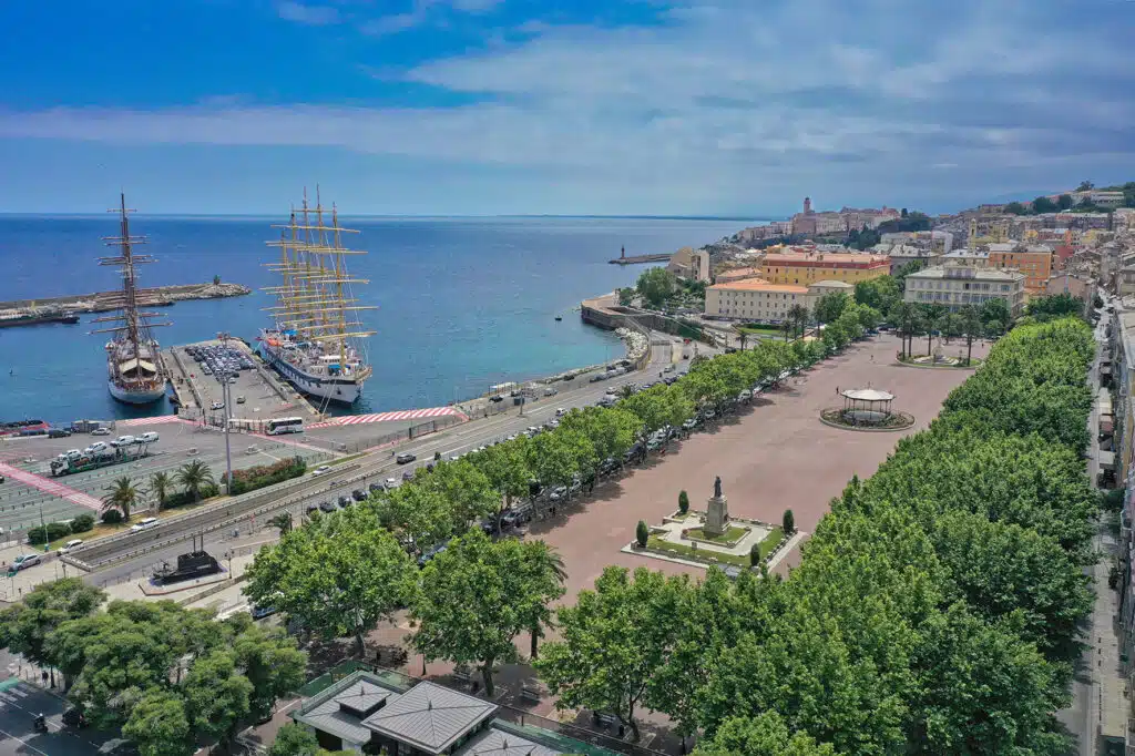 Vue aérienne sur la place Saint Nicolas en plein jour avec à coté le port de commerce de Bastia